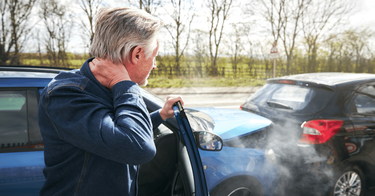 Adult man getting out of the car holding his neck after a car accident injury
